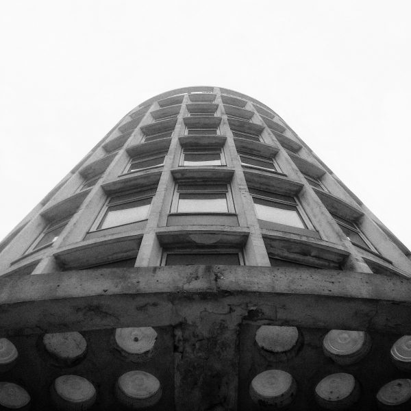 Looking up at the side of a brutalist building with many windows